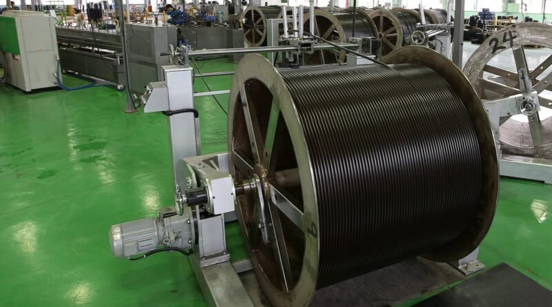 Production line with large hose reels on the green floor of a factory in a South Korean industrial complex